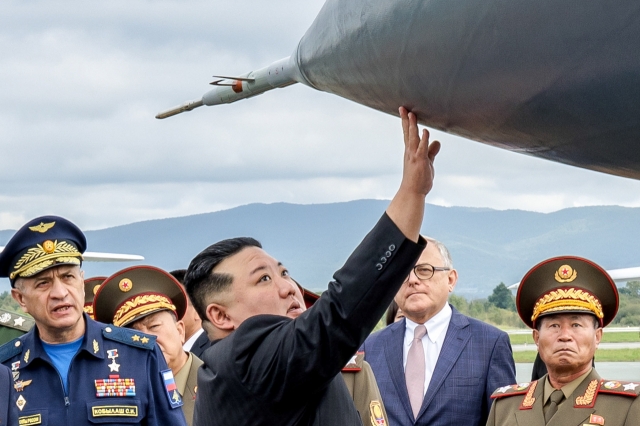 Sergei Kobylash (left), commander of the Russian Aerospace Forces' long-range aviation, and North Korea's leader Kim Jong-un (center) are seen at Vladivostok International Airport during Kim's visit to Russia in September. (ITAR-TASS-Yonhap)