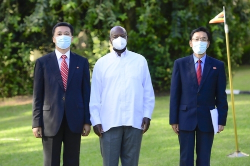 Museveni (center) and North Korea's Ambassador to Kampala, Jong Tong-hak, (left), posing for a photo at State House, Entebbe, as Jong, the outgoing envoy, paid a courtesy call to him on Tuesday. (Yonhap)