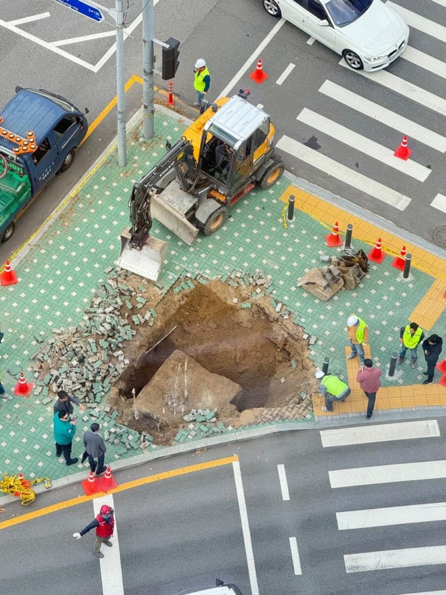 A 4-meter deep sinkhole opened up on a traffic island between IFC Mall and Parc 1 Tower in Yeouido, western Seoul on Wednesday. (Yonhap)