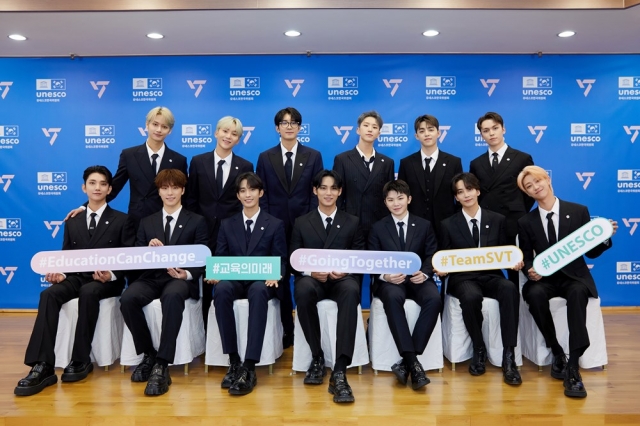 A picture provided by Pledis Entertainment shows Seventeen members posing after they sign a business partnership for the 