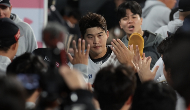 Bae Jung-dae of the KT Wiz (center) is congratulated by teammates in the dugout after scoring a run against the NC Dinos during Game 2 of the Korea Baseball Organization postseason at KT Wiz Park in Suwon, Gyeonggi Province, on Tuesday. (Yonhap)