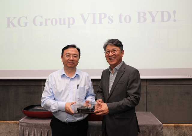 BYD Chairman Wang Chuanfu (left) and KG Mobility Chairman Kwak Jae-sun hold a miniature car during the signing ceremony for their new partnership at the Chinese firm's headquarters in Shenzhen, China, Wednesday. (KG Mobility)