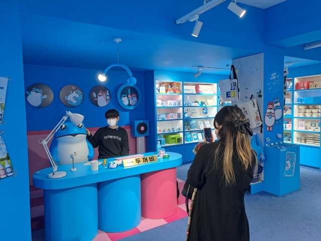 A visitor poses for photos at Dookkeop Arcade in Gangnam, southern Seoul, in February. (Lee Si-jin/The Korea Herald)