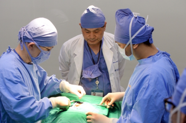 In this file photo from 2014, disgraced scientist Hwang Woo-suk (center) oversees a cloning procedure at Sooam Biotech Research Foundation, which he founded, in Seoul. (Park Hyun-koo/The Korea Herald)