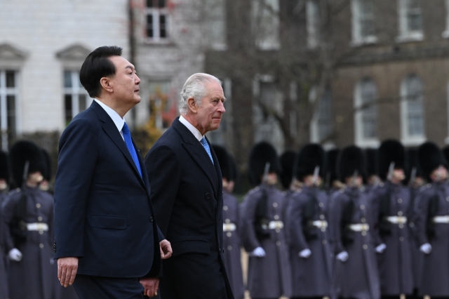 President Yoon Suk Yeol (left) and King Charles III inspect troops from the UK honor guard at Horse Guards Parade on Tuesday. (Pool photo via Yonhap)