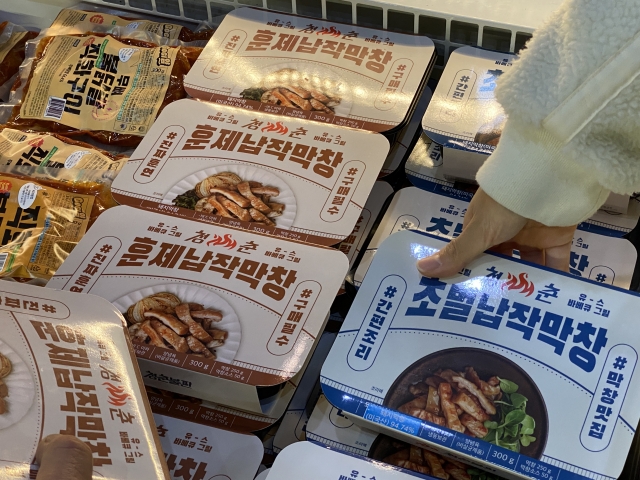 A visitor picks up a makchang, or beef intestine, meal kit from Cheongchun Bulpan, at 2023 Coex Food Week, held at Coex in southern Seoul, Wednesday. (Hwang Joo-young/The Korea Herald)