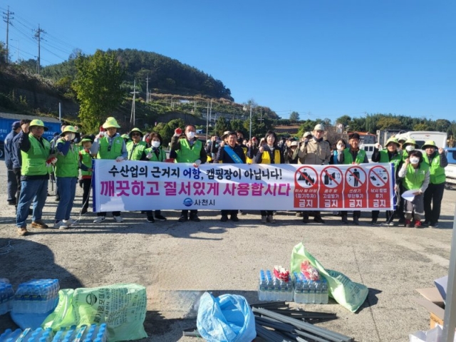 Local residents and officials from an environmental organization pose for a photo at Neukdo port in Sacheon City, South Gyeongsang Province, Nov. 12, 2023. (Courtesy of Sacheon City Hall)