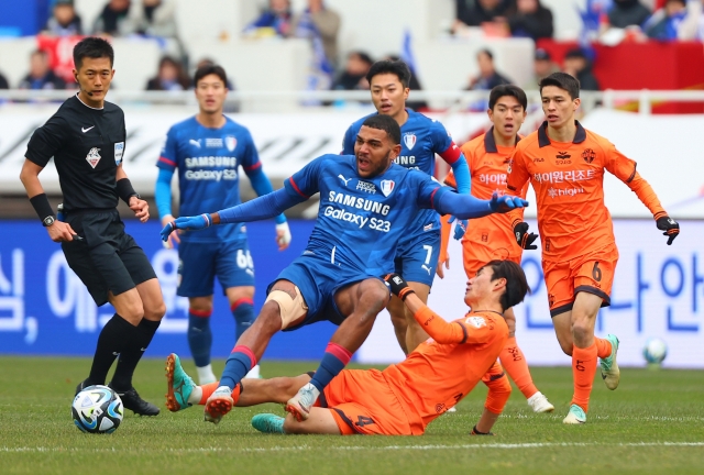 Rodrigo Bassani of Suwon Samsung Bluewings is tackled by Seo Min-woo of Gangwon FC during the clubs' K League 1 match at Suwon World Cup Stadium in Suwon, Gyeonggi Province, on Saturday. (Yonhap)