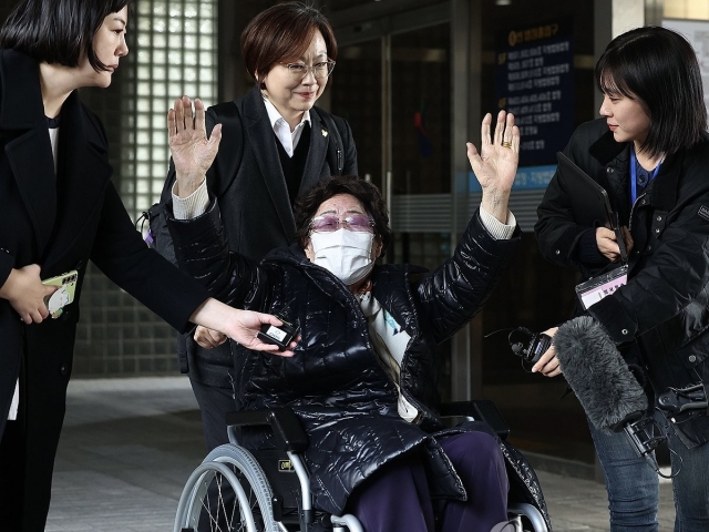 Lee Yong-soo, one of the nine registered surviving South Korean victims of sexual slavery by Japan during World War II, raises her hands in a victorious gesture after the appeals court in Seoul ordered Japan to compensate her and other victims, on Nov. 23. (Yonhap)