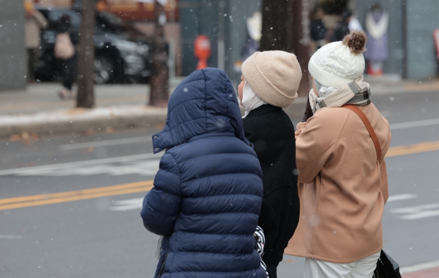 Bundled-up children wait to cross the road near Gyeongbokgung in Jongno-gu, Seoul, on Saturday. (Yonhap)