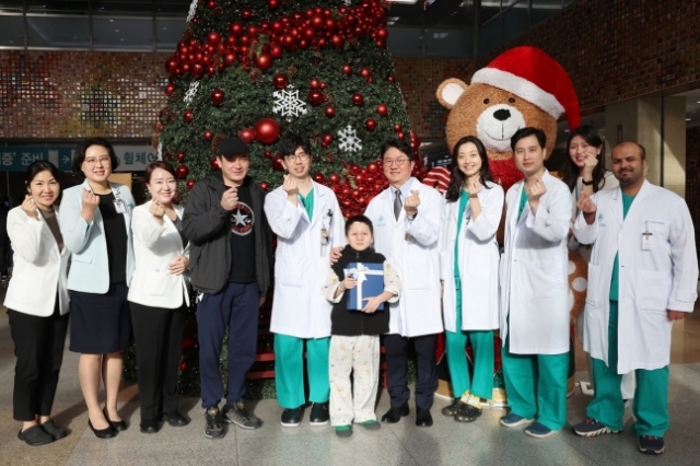 Alinur, center, poses with the medical staff from Asan Medical Center. (Asan Medical Center)