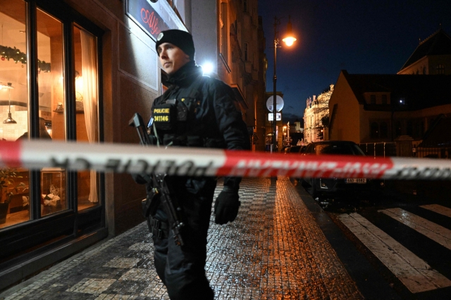 A police officer secures the area near the Charles University in central Prague, on Thursday. A gunman killed 10 people and wounded dozens of others at a Prague university on Thursday, before the police 