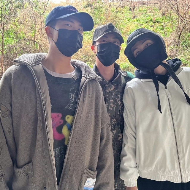 RM (left) and V (right) pose with Jin before enlisting for their mandatory military service on Dec. 11, in front of Nonsan Training Center in South Chungcheong Province. (Yonhap)