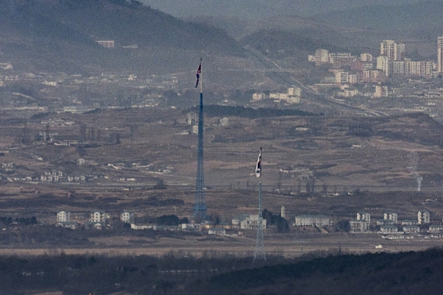 A South Korean flag in the South's Daeseong-dong and a North Korean flag in the North's Kijong-dong face each other on the western border in this photo taken from the South Korean border city of Paju on Dec. 18. (Yonhap)