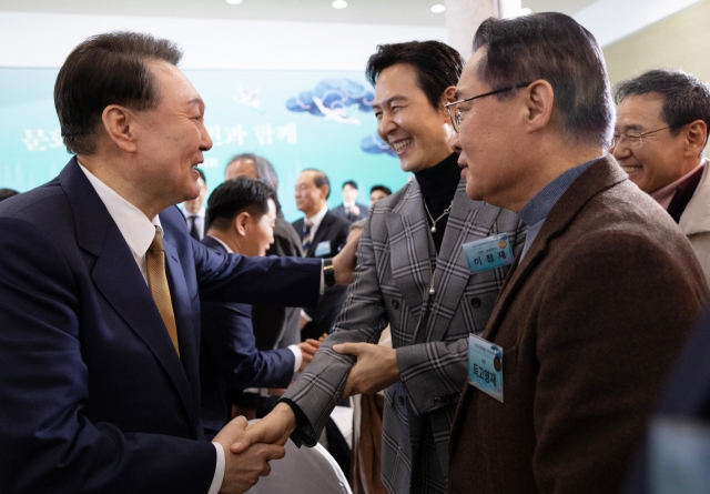 President Yoon Suk Yeol shakes hands with 