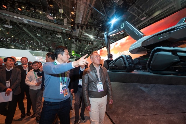 HD Hyundai Vice Chairman Chung Ki-sun (left) speaks to Hyundai Motor Group Executive Chair Chung Euisun as the two business moguls of the Hyundai Group look around HD Hyundai's exhibition area at the CES 2024 in Las Vegas on Tuesday. (HD Hyundai)