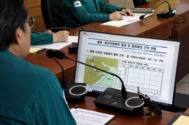 Oceans and Fisheries Minister Kang Do-hyung (left) speaks with the skipper of a South Korean vessel passing near the Red Sea over the phone at the ministry's situation room in the government complex in Sejong, 112 kilometers south of Seoul, on Jan. 12, following US and British strikes against Houthi targets in Yemen in response to Red Sea attacks by the Houthis. (Yonhap)