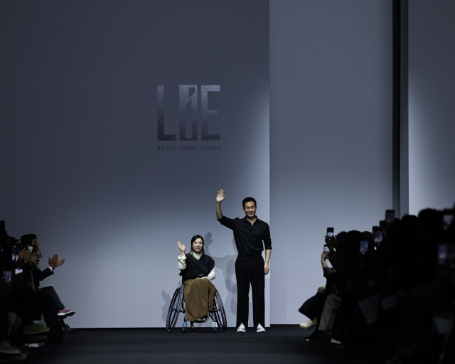 LIE’s Lee Chung-chung (right) and a model in a wheelchair during Seoul Fashion Week at Dongdaemun Design Plaza in Seoul on Friday (Seoul City)