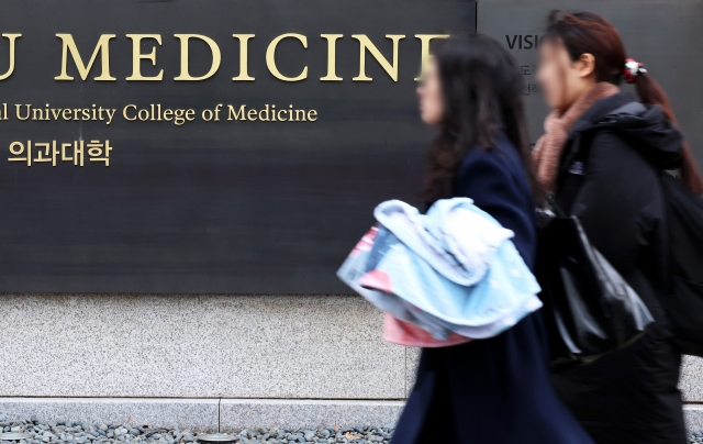 People walk by the College of Medicine at a university in Seoul, Monday. (Yonhap)