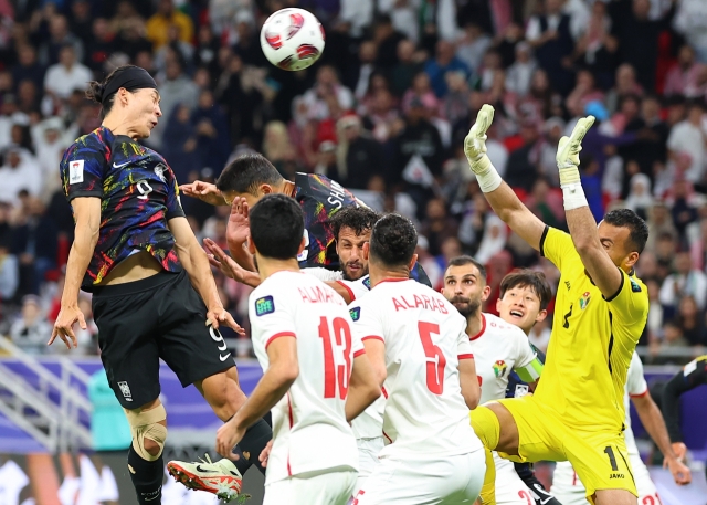 Cho Gue-sung (left) attempts a header against Jordan at the Ahamd bin Ali Stadium in Qatar on Tuesday. (Yonhap)