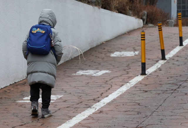 A student enters an elementary school in Seoul to attend an after-school program. (Yonhap)