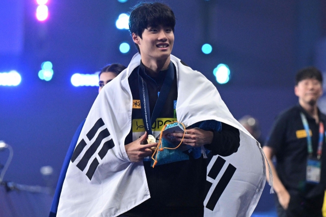 Hwang Sun-woo of South Korea celebrates during the medal ceremony after winning the men's 200-meter freestyle title at the World Aquatics Championships at the Aspire Dome in Doha on Tuesday. (AFP-Yonhap)