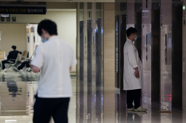 Doctors walk at a hospital in Seoul on Friday. (Yonhap)