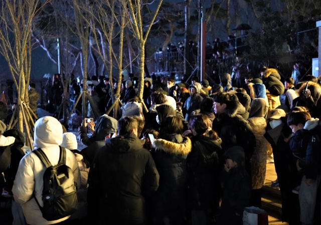 Spectators try to capture the moment when the annual Jeongwol Daeboreum is celebrated at Aegibong Peace Ecopark in Gimpo, Gyeonggi Province. (Lee Si-jin/The Korea Herald)