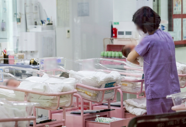 A worker cares for newborns at a postpartum care center in Seoul, Wednesday. (Joint Press Corps)