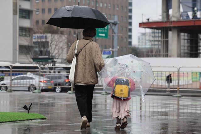 A mother and her child take a walk near Gwanghwamun Square in Jongno-gu on Feb. 15. (Yonhap)