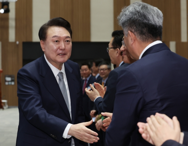 President Yoon Suk Yeol (left) shakes hands with Daewoo E&C Chair Jung Won-ju at the GTX Line B groundbreaking ceremony in Incheon, Thursday. (Pool photo via Yonhap)