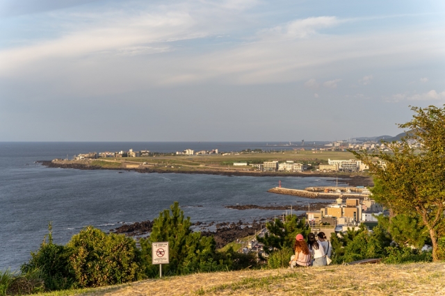 People sit in an open field at Dodubong on Jeju Island. (Jeju Tourism Organization)