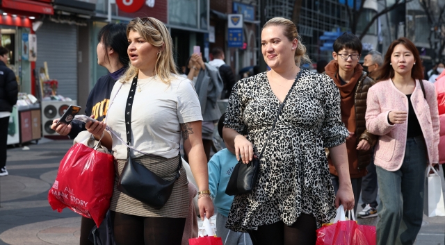 Foreign tourists walk on the main street in the Myeong-dong area, Seoul, on Feb. 14. (Yonhap)