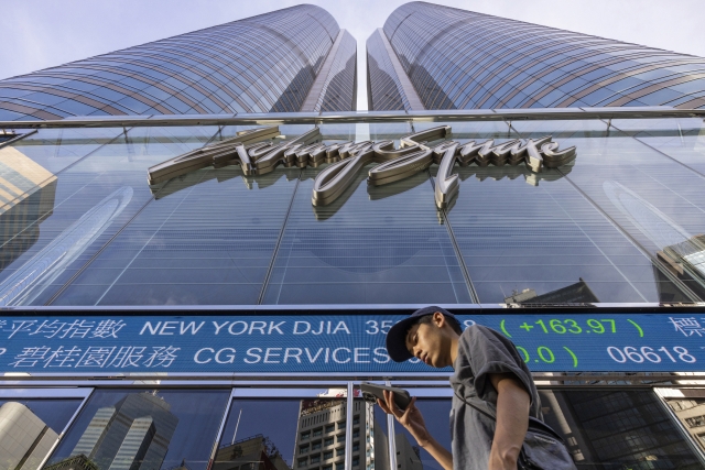 In this file picture, a pedestrian passes by a Hong Kong Stock Exchange electronic screen in Hong Kong on July 21, 2023. (AP)