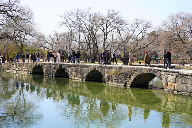 People walk across Ojakgyo at Gwanghallu Garden on March 10. (Lee Si-jin/The Korea Herald)