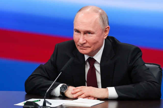 Russian President and presidential candidate Vladimir Putin gestures during a meeting with the media at his campaign headquarters in Moscow on Monday. (TASS-Yonhap)