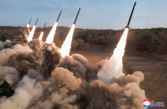 This photo carried on Tuesday shows the North's firing drills involving super-large multiple rocket launchers the previous day. (KCNA)