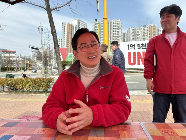 Rep. Park Soo-young (center) of the ruling People Power Party speaks to The Korea Herald at Peace Park in Nam-gu, Busan, Sunday. (Kim Arin/The Korea Herald)