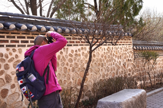 A visitor takes a photo at Yunboseon-gil in Jongno-gu, Seoul, Monday. (Lee Si-jin/The Korea Herald)