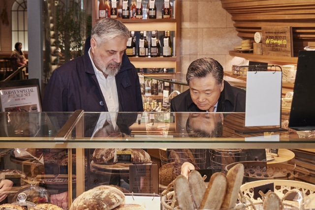 SPC Group Chair Hur Young-in (right) and Caffe Pascucci CEO Mario Pascucci tour around Passion5, SPC Group's flagship bakery and dessert store in central Seoul, Sunday. (SPC Group)