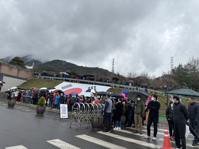 Crowds wait outside the home of former President Park Geun-hye in Daegu on Tuesday, following news that leaders of the ruling People Power Party were due to visit. (Kim Arin/The Korea Herald)