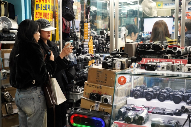 Visitors browse camera lenses and other equipment at a store at the Sewoon Shopping Center, March 21. (Lee Si-jin/The Korea Herald)