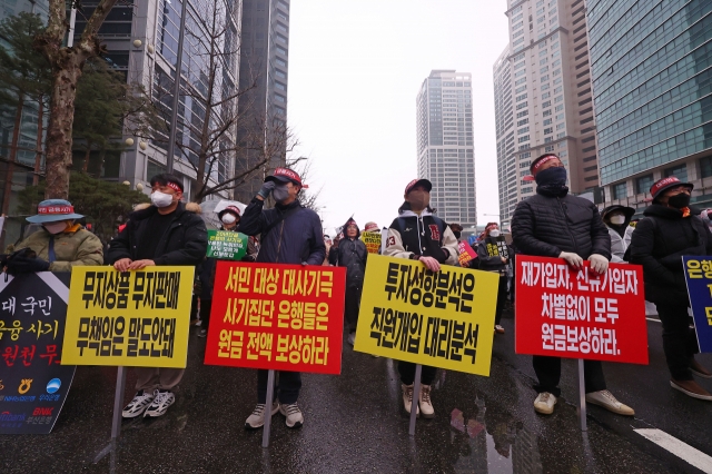 A group of people who claim to have suffered from the misselling of equity-linked securities tied to Hong Kong's Hang Seng China Enterprises Index, stage a protest in front of the headquarters of KB Kookmin Bank, Friday. (Yonhap)