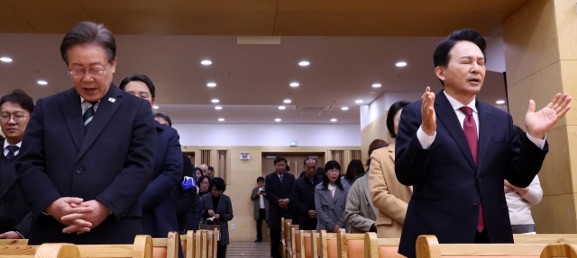 EASTER BRINGS TOGETHER RIVALS -- Rep. Lee Jae-myung (left), chair of the Democratic Party of Korea, and Won Hee-ryong (right), former minister of land and transport for President Yoon Suk Yeol, attend an Easter service on March 31 at a Presbyterian church in Incheon’s Gyeyang-gu, where the two are running against each other in the B constituency for the April 10 general election. (Yonhap)