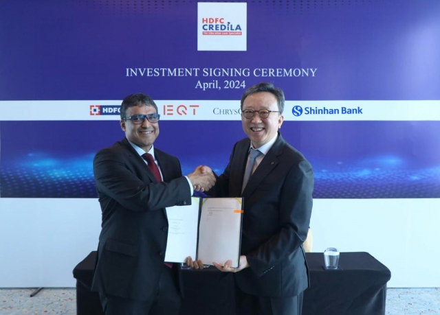 Shinhan Bank CEO Jung Sang-hyuk (right) and Credila CEO Arijit Sanyal shake hands during a signing ceremony at The St. Regis Mumbai, in Mumbai, India, Wednesday. (Shinhan Bank)