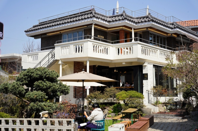 Customers take a break at the garden of Cafe Booter in Suwon, Gyeonggi Province, Monday. (Lee Si-jin/The Korea Herald)