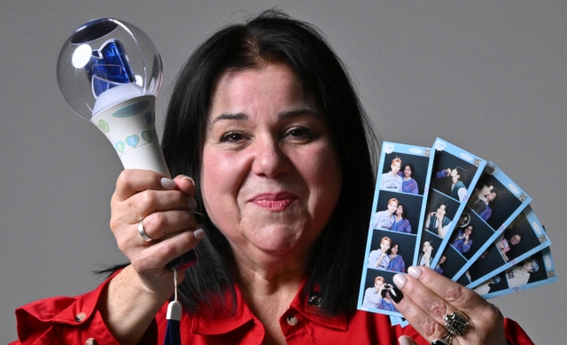 Julia Bellaflores poses for a photo with a WEi light stick and instant photos after her interview with The Korea Herald on Feb. 7. (Im Se-jun/The Korea Herald)