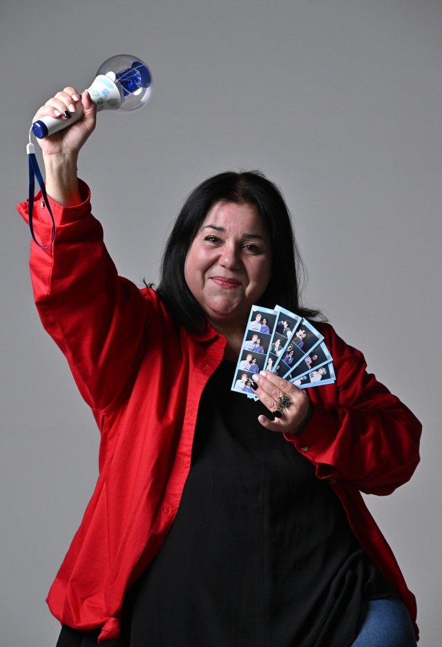 Julia Bellaflores poses for a photo with a WEi light stick and instant photos after her interview with The Korea Herald on Feb. 7. (Im Se-jun/The Korea Herald)