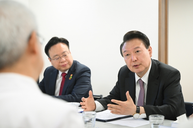 President Yoon Suk Yeol, right, speaks with doctors during a visit to a hospital in Bucheon, west of Seoul, on April 9. (Yonhap)