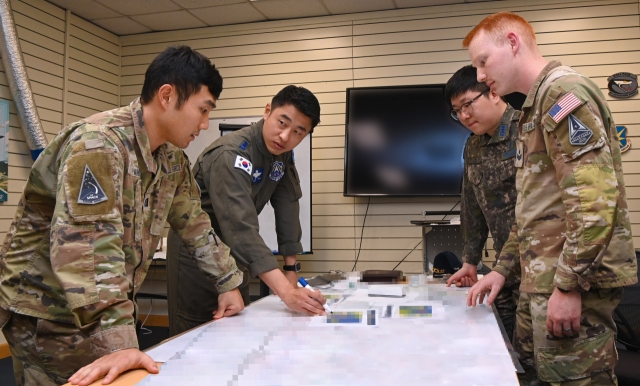 Military personnel of the South Korean Air Force's Space Operation Squadron and the United States Space Forces Korea analyze coordinates of jamming attacks during joint training exercises held at an air base in Gunsan, 178 kilometers south of Seoul, on Monday. (Air Force)